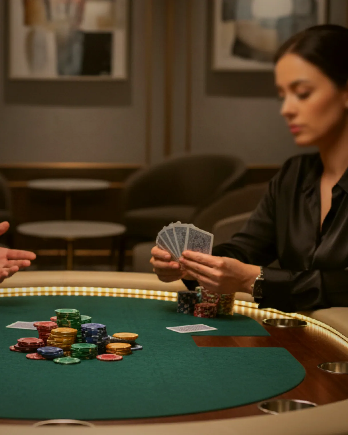 A house dealer dealing a hand of five hundred across green baize to four waiting players.